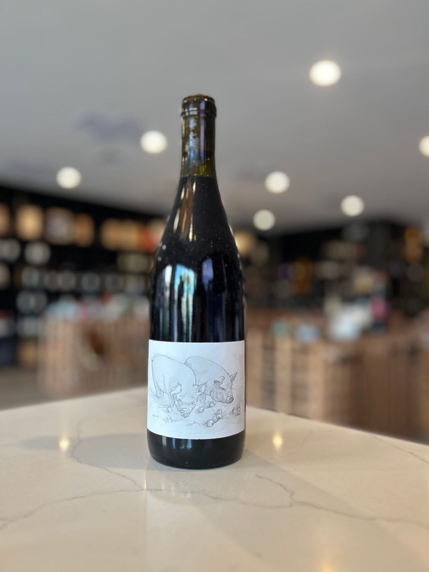 Wine bottle with a label on a counter in a wine store.