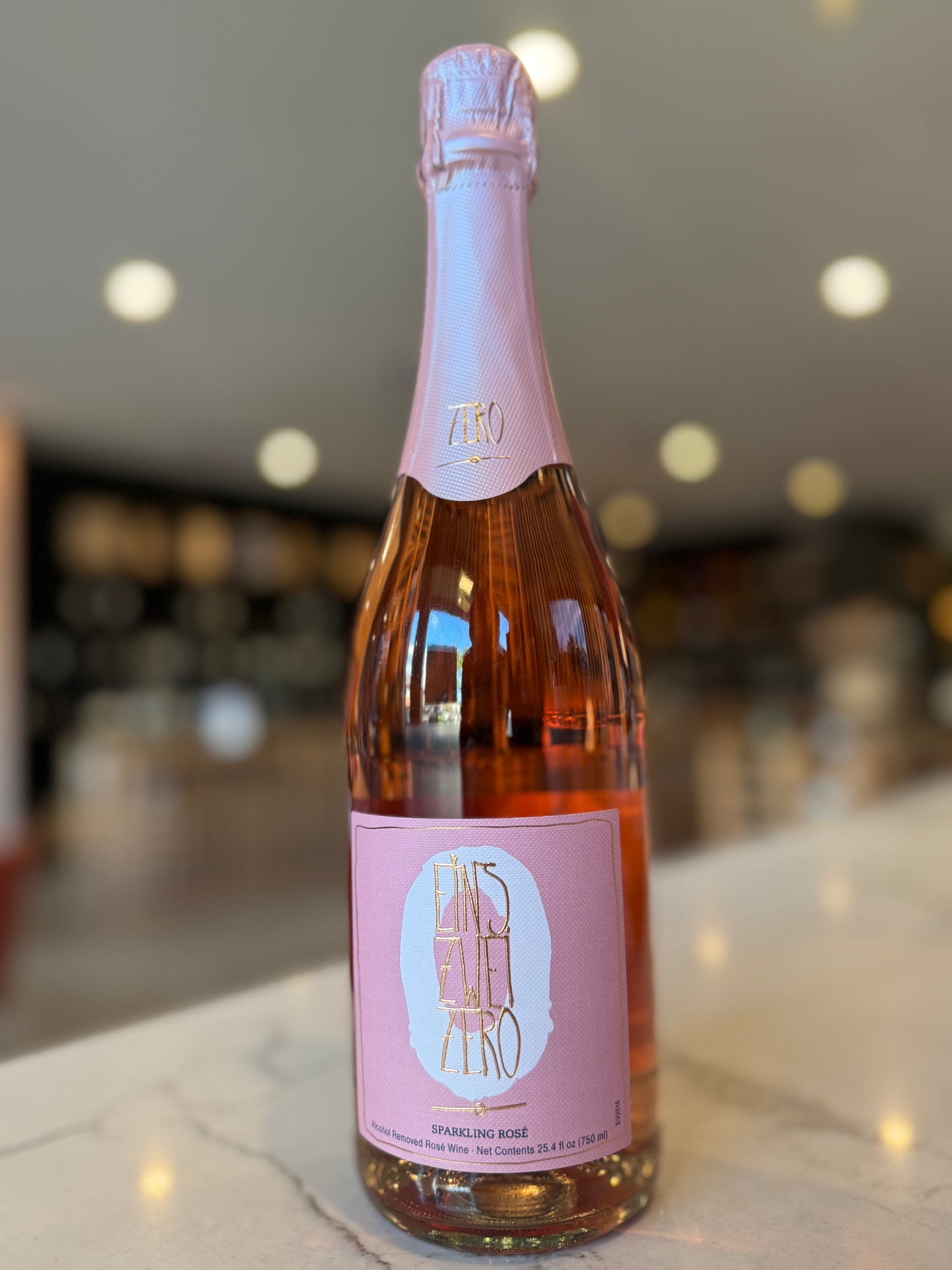 Bottle of rosé wine with a pink label on a blurred background
