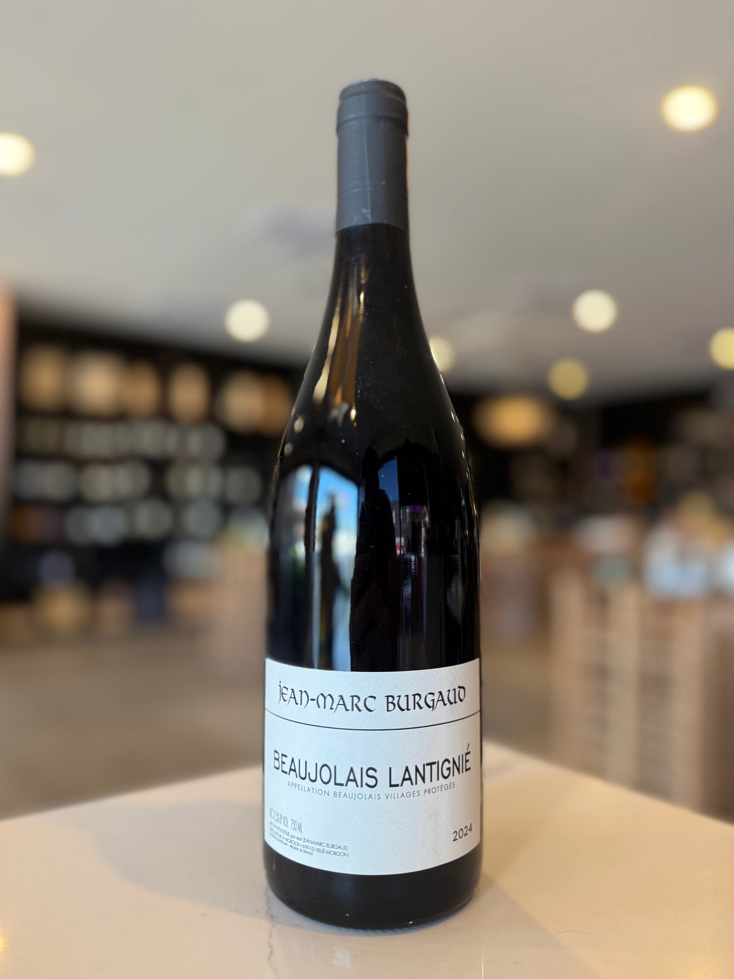 Wine bottle with a label on a counter in a blurred store setting