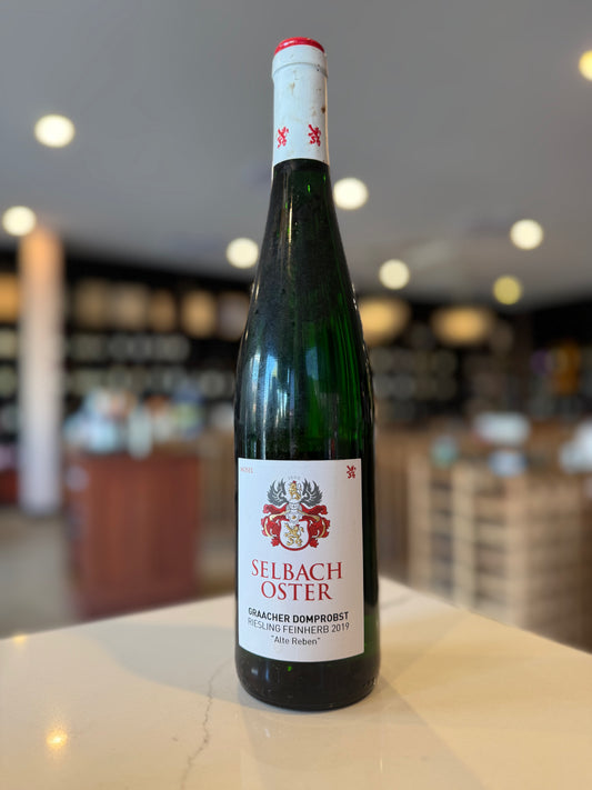 Bottle of Selbach Oster wine on a counter with a blurred store background