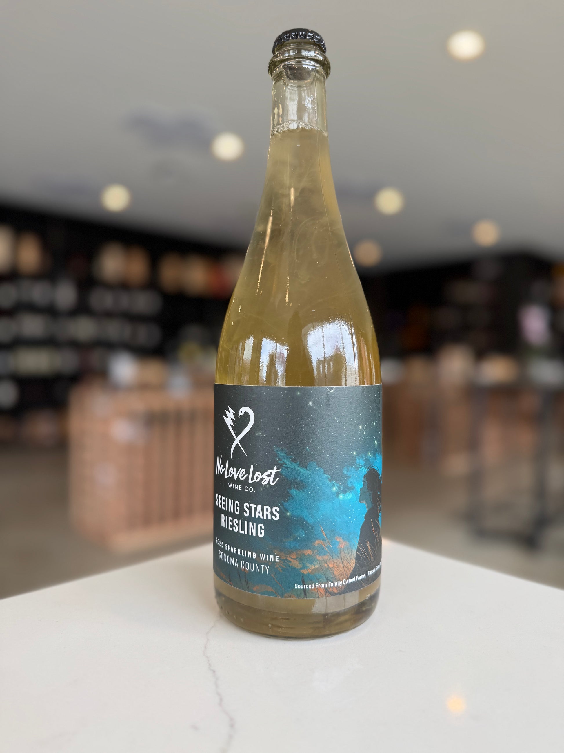 Bottle of wine with a label on a white surface, blurred background