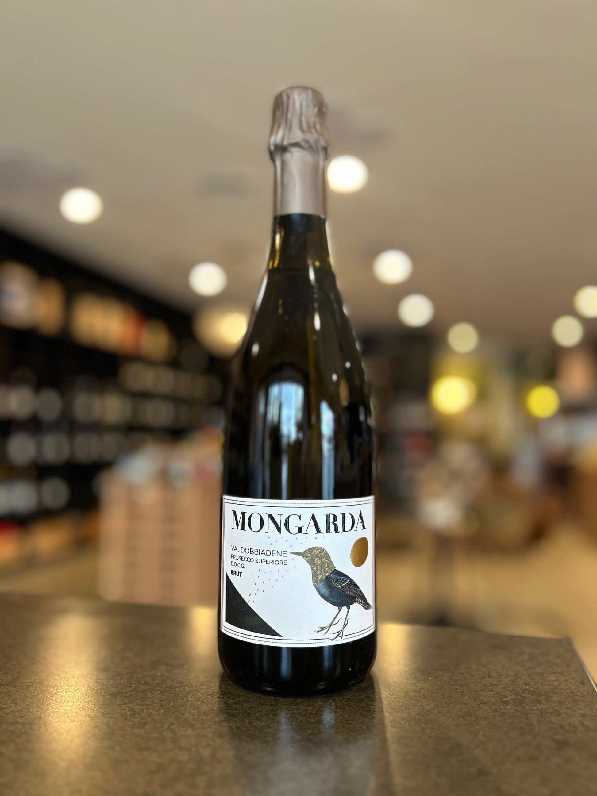 Bottle of Mongarda wine on a bar counter with a blurred bar background