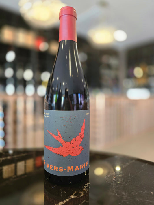 Wine bottle with a label featuring a red bird design on a blurred background